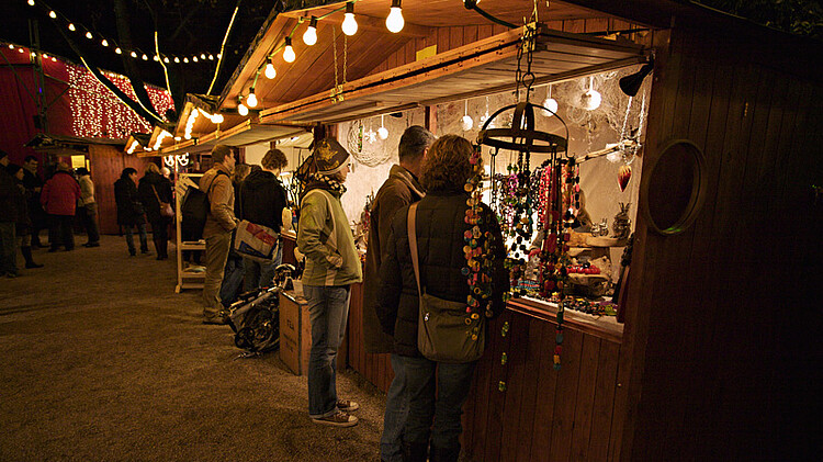 Menschen schauen sich einen Weihnachtsstand an