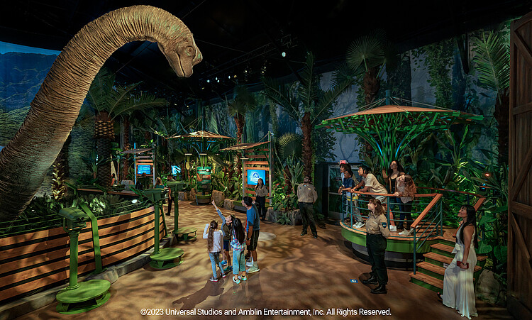 Besucher gehen an einem Langhalsdino entlang