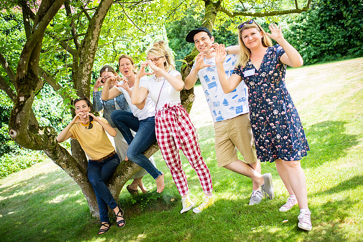 Menschen im Park zeigen ein Herz mit ihren Händen